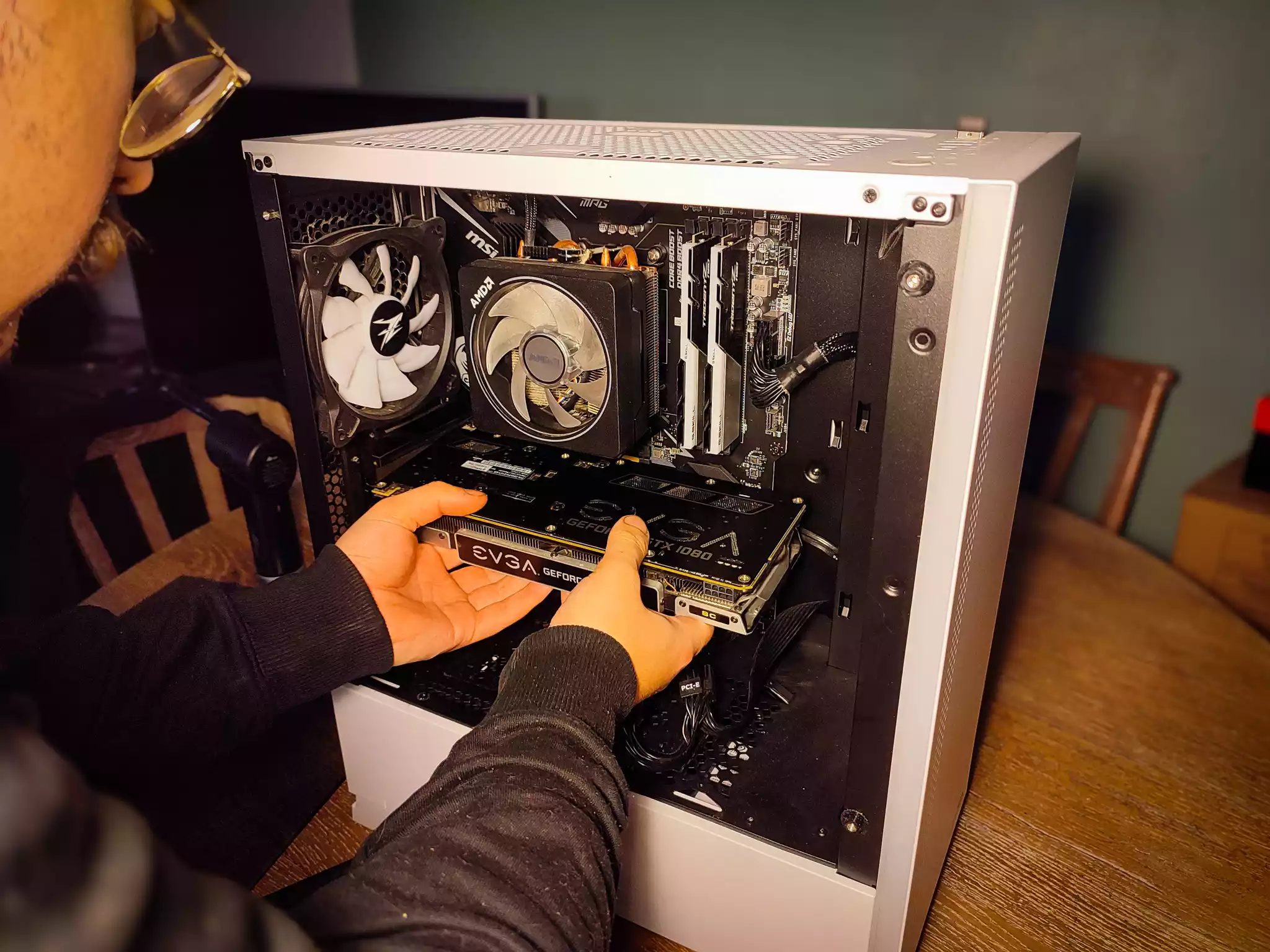 Pose d'un composant (carte graphique) dans une tour d'ordinateur.